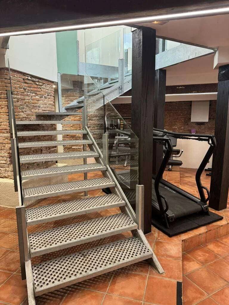 Vue intérieure du cabinet : escalier et tapis de course